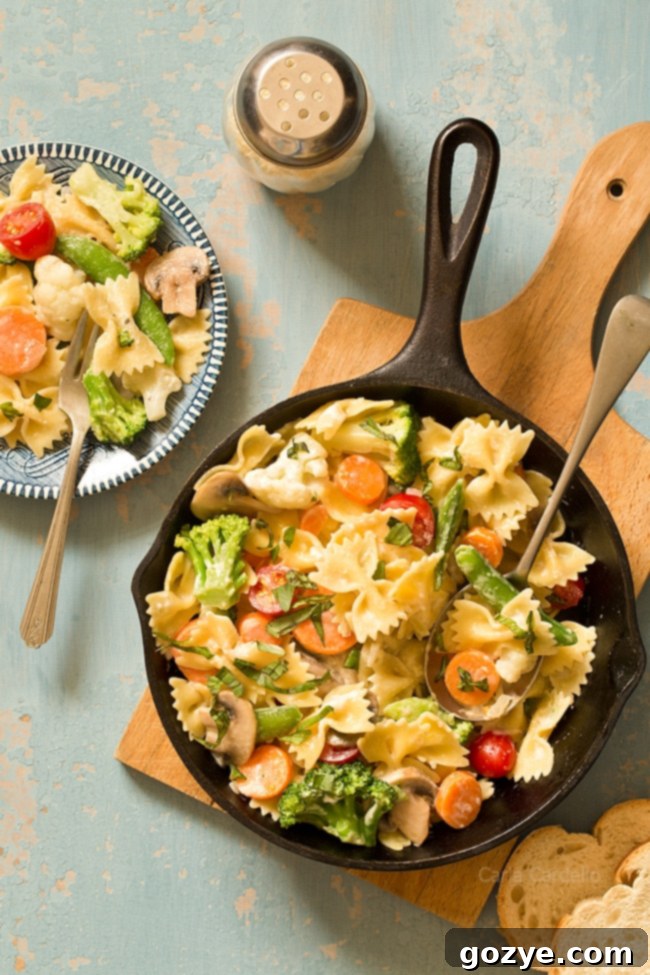 Vibrant One Skillet Pasta Primavera with a creamy Parmesan sauce, featuring fresh vegetables, chicken, and shrimp options for customization.
