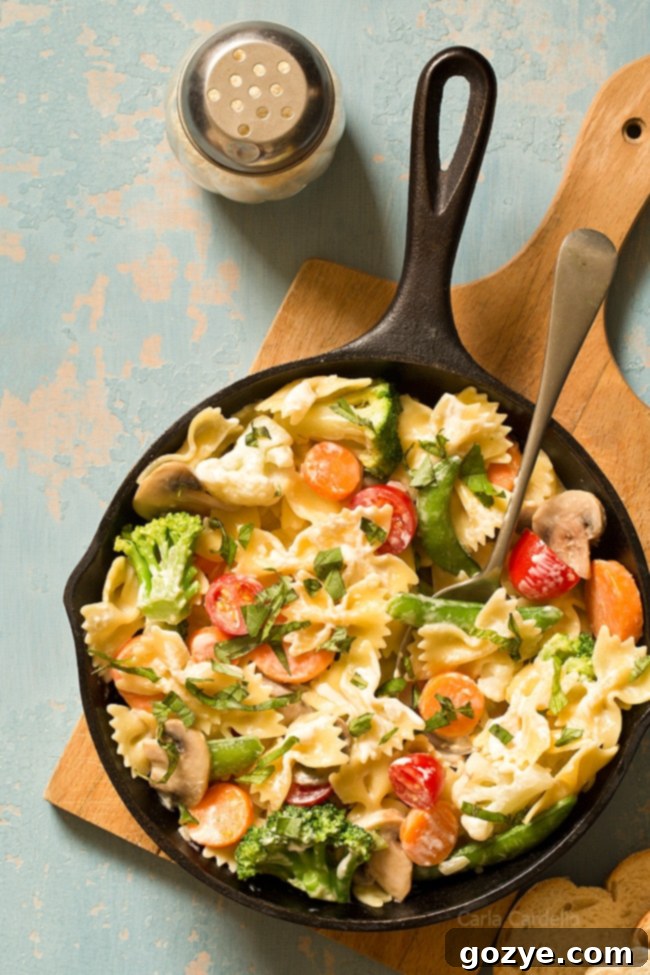 Appetizing One Skillet Pasta Primavera with a creamy Parmesan sauce, ready to serve, garnished with fresh basil.