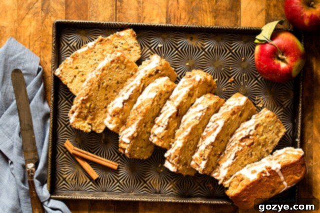 Delicious slice of Cinnamon Apple Bread with streusel and white icing on a cooling rack.