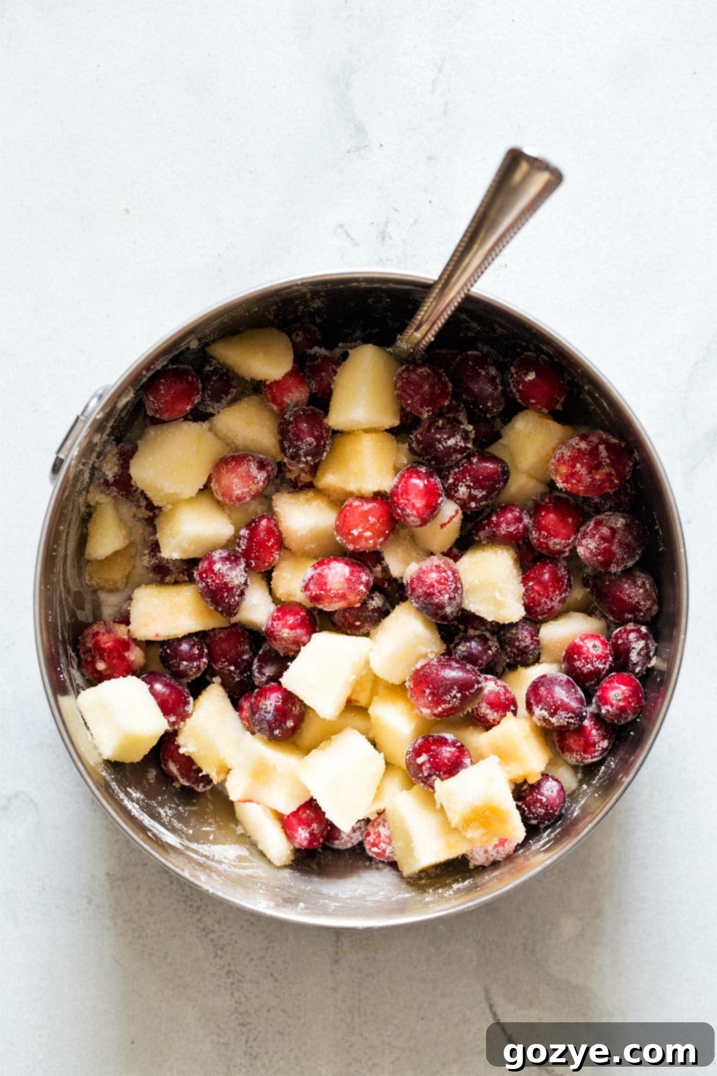 Mixing together cranberries, apple, sugar, cornstarch, and vanilla for cranberry crisp