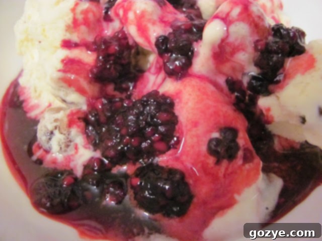 Freshly made Black Raspberry Sauce in a glass bowl with a spoon