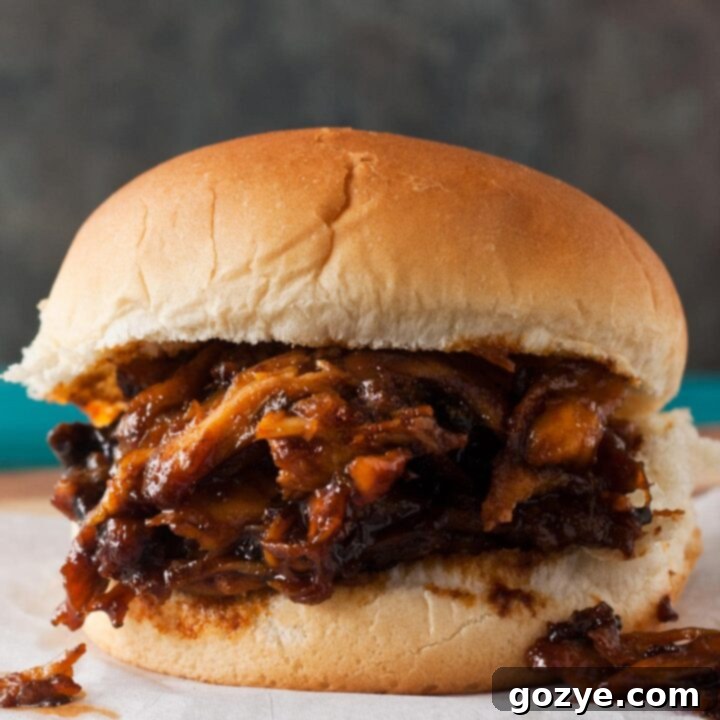 Set-It-and-Forget-It BBQ Pulled Chicken 5 Slow Cooker BBQ Pulled Chicken sandwiches on parchment paper