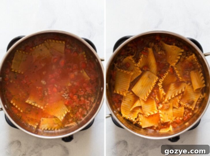 Lasagna noodles cooking directly in the simmering lasagna soup broth in a Dutch oven.