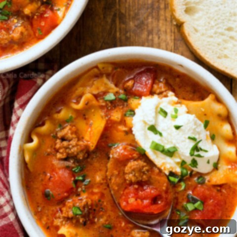 One-Pot Lasagna Soup in a bowl with a spoon, garnished with basil and parmesan
