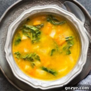Kohlrabi Soup with Kohlrabi Greens in a silver ridged bowl on a dark gray plate