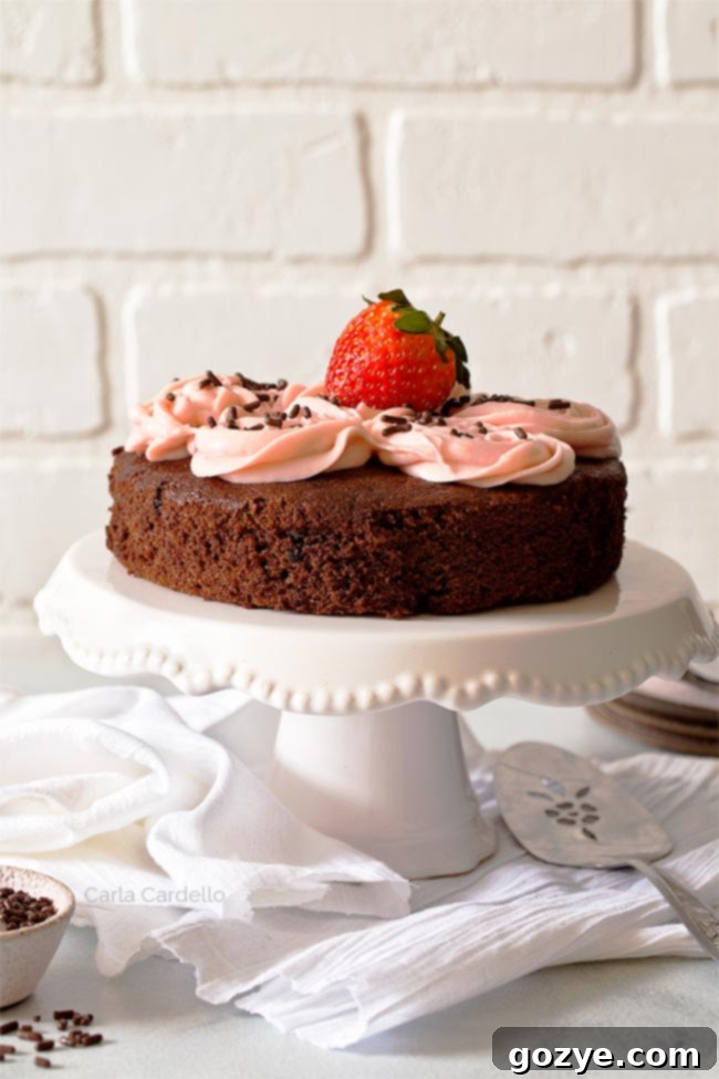 Chocolate cake with strawberry frosting on white cake stand, perfectly sized for two