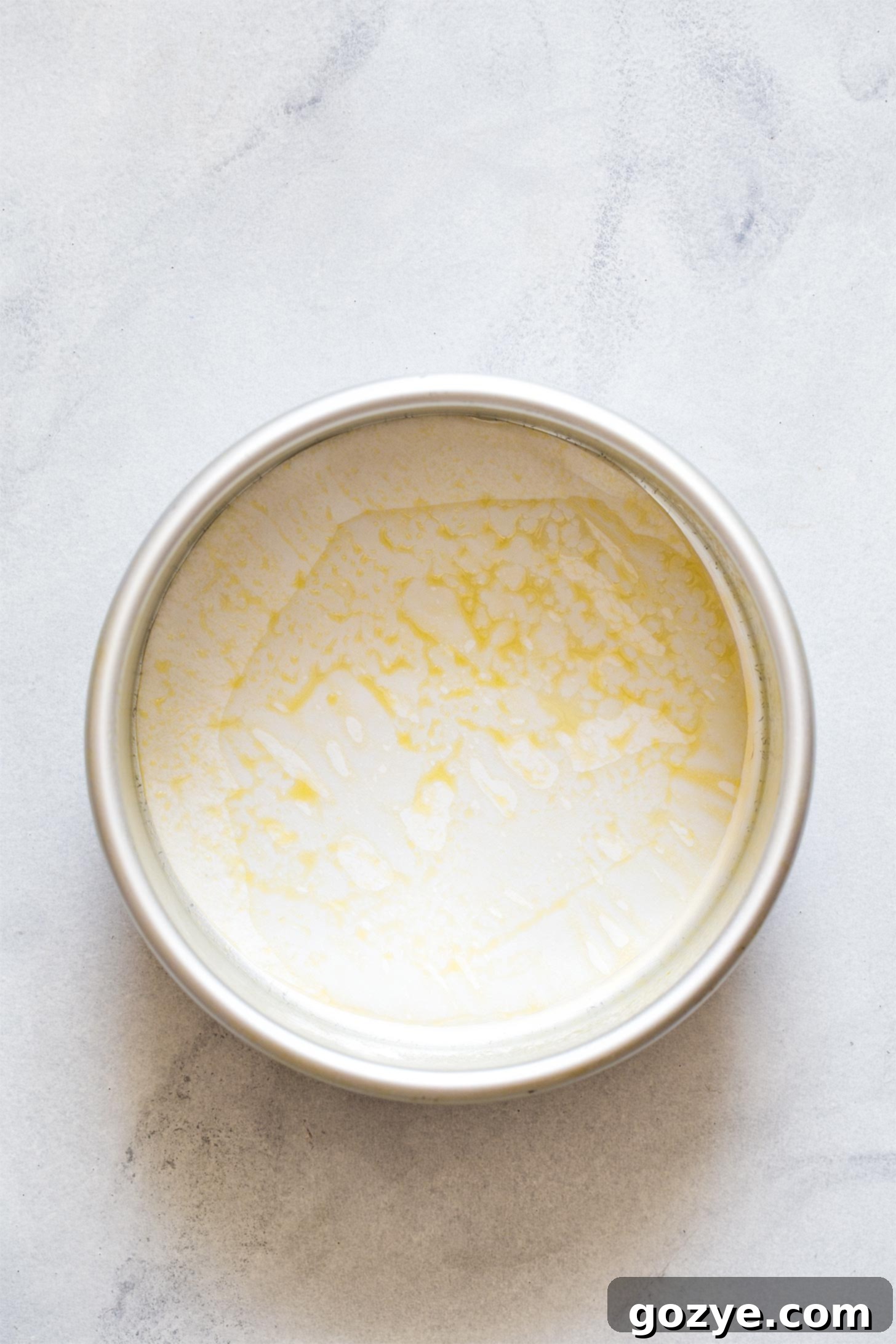 A 6-inch cake pan perfectly lined with parchment paper, ready for batter