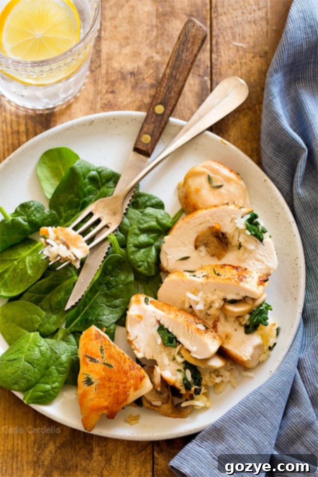 Rice Stuffed Chicken with mushroom, cheese, and spinach sliced on a white dinner plate