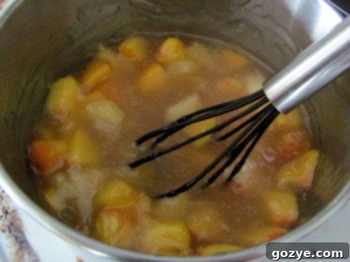 Homemade peach pie filling cooking in a saucepan