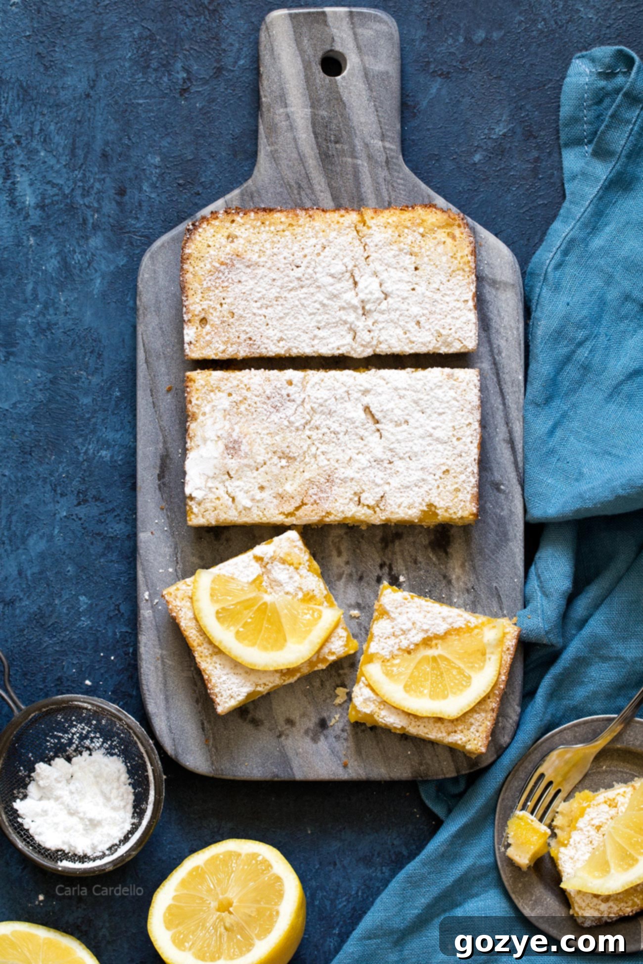 Zesty Small Batch Lemon Bars 8 Lemon bars, some whole and some cut, artfully placed on a marble cutting board, ready for a dessert spread