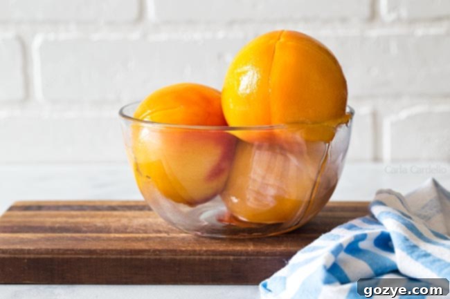 Glass bowl with 3 peeled peaches