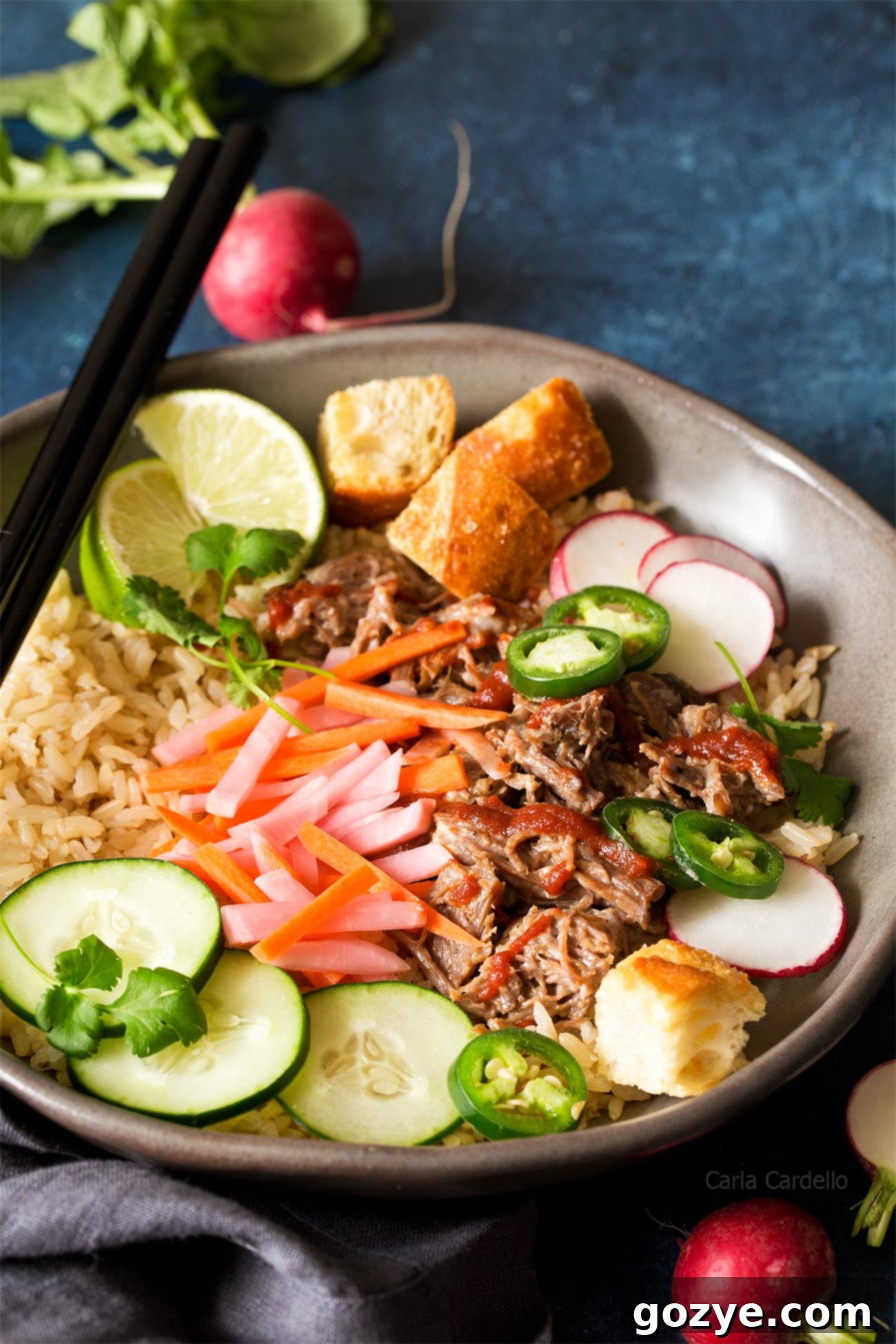 Slow Cooker Banh Mi Rice Bowls with shredded pork, pickled carrots, pickled radishes, and baguette croutons