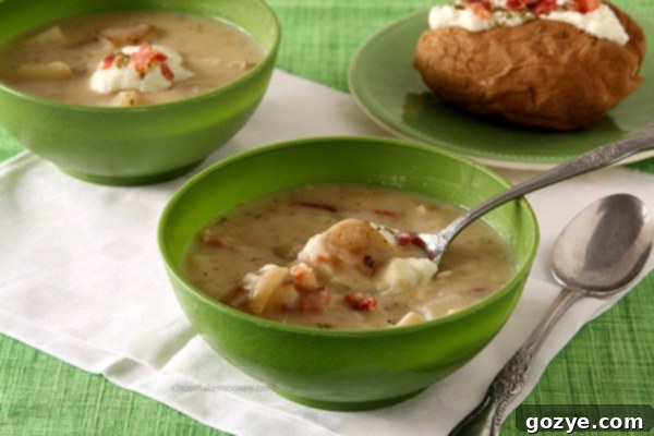 A close-up of the delicious baked potato soup simmering, showing the rich, creamy texture and small potato cubes.
