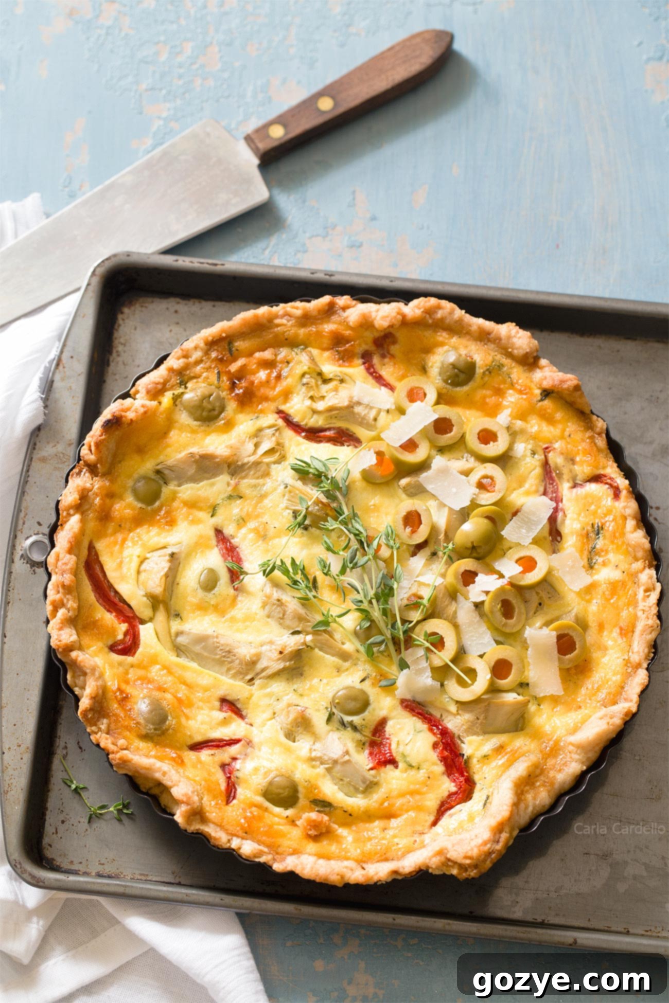 Vegetarian Artichoke Quiche on a baking sheet, golden brown and ready to serve.
