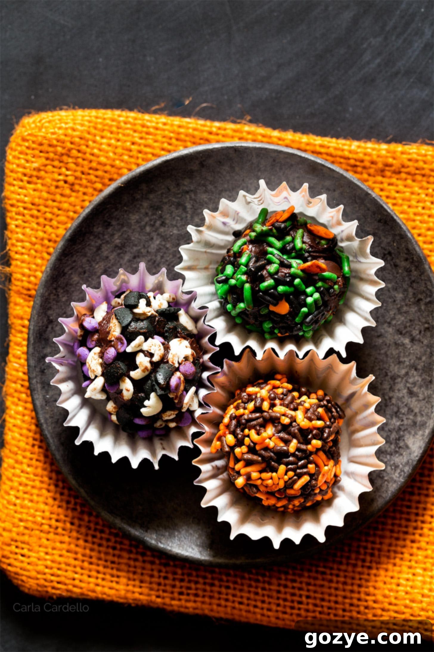 Close-up view of multiple chocolate truffles, showcasing their rich texture and perfect spherical shape.