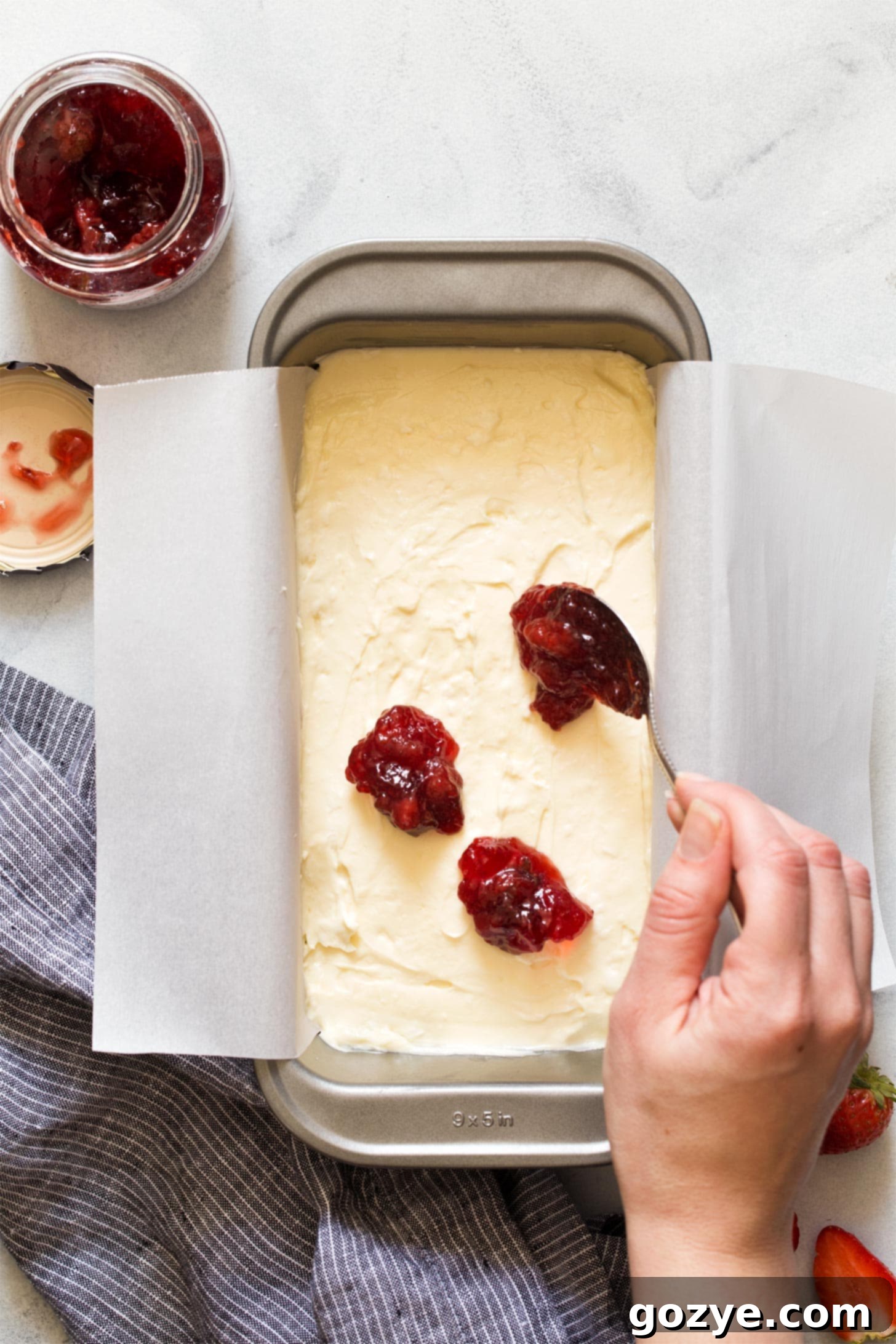 Adding strawberry jam to loaf pan cheesecake