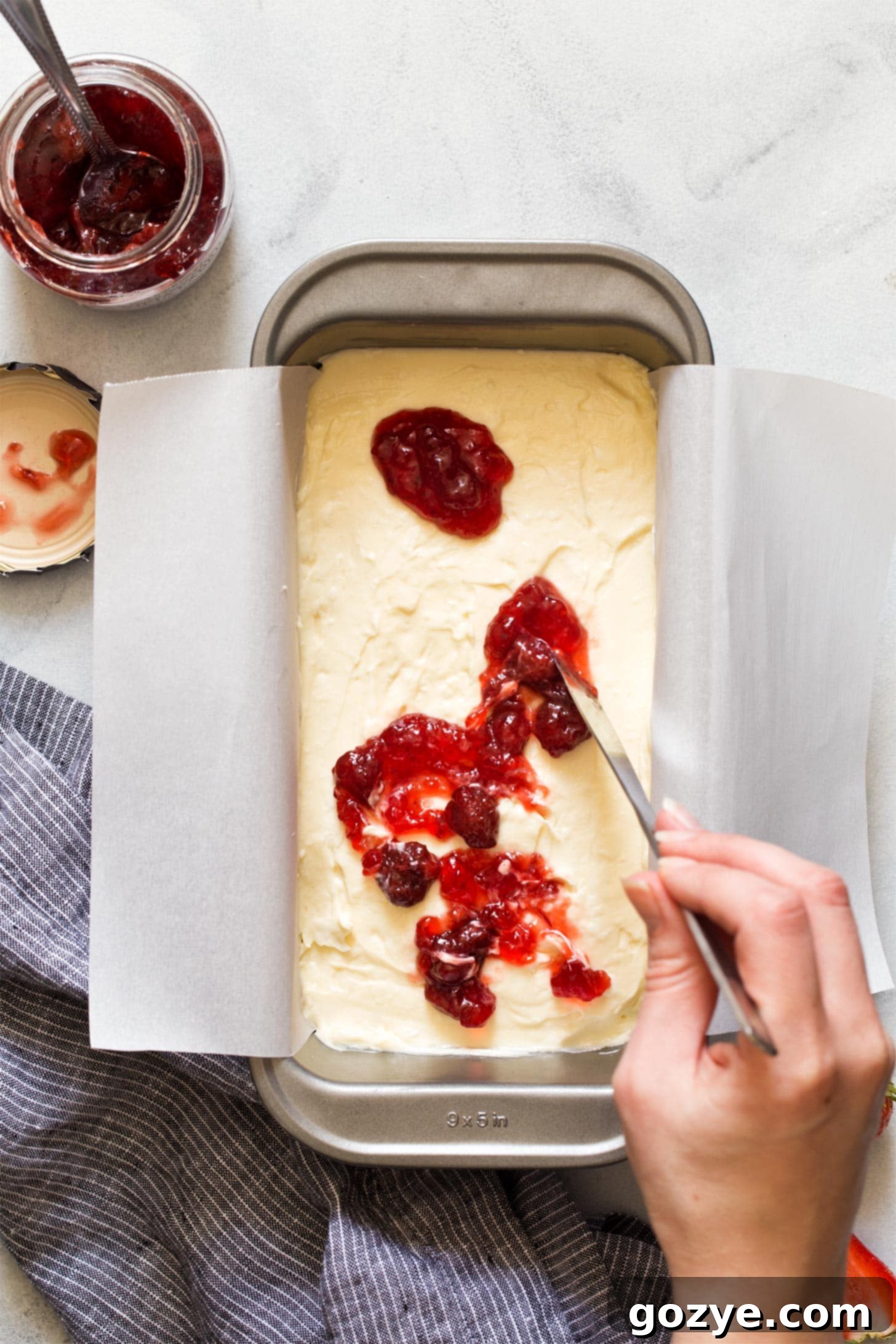 Swirling strawberry jam into cheesecake bars