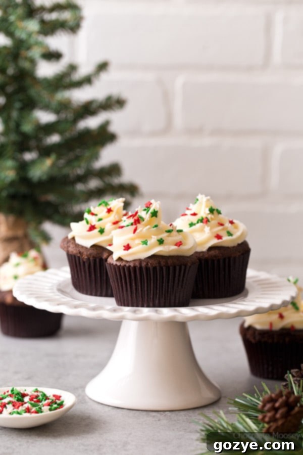 These small batch Chocolate Gingerbread Cupcakes with homemade cream cheese frosting makes a half dozen cupcakes. Ideal for when you want a small Christmas dessert without too many leftovers. A close-up shot of the beautifully frosted cupcakes, adorned with festive sprinkles.