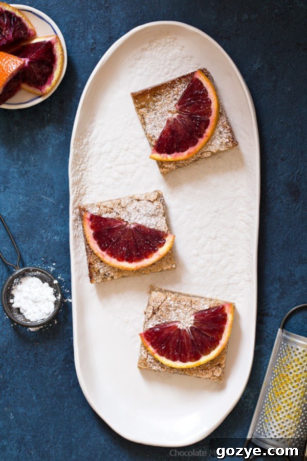 Delicious Blood Orange Bars showcasing a buttery crust and soft, vibrant orange filling, dusted with powdered sugar, ready to be enjoyed.