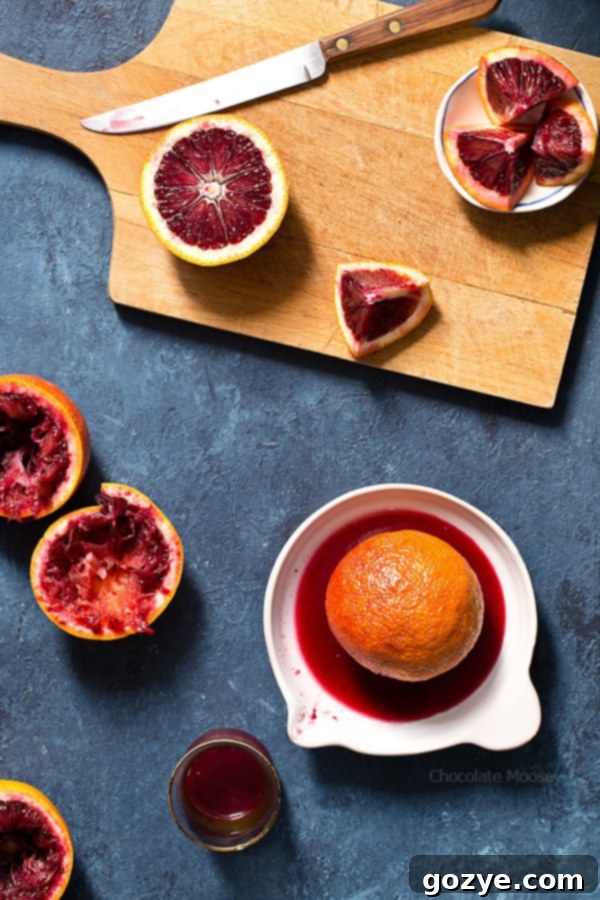 Various types of blood oranges displayed, with a focus on their distinctive reddish-orange peels and rich, deep red interiors.