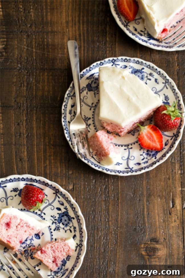 Small 6 Inch Strawberry Cake made with fresh strawberries and no Jello. Top-down view of the pink frosted cake decorated with fresh strawberry slices.