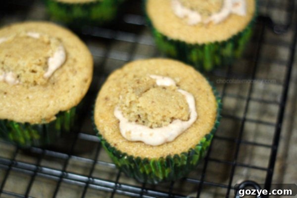 A trio of perfectly frosted Irish Cream Cupcakes on a rustic wooden surface