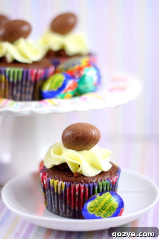 Close-up of a decorated Cadbury Creme Egg Cupcake with mini Creme Egg garnish