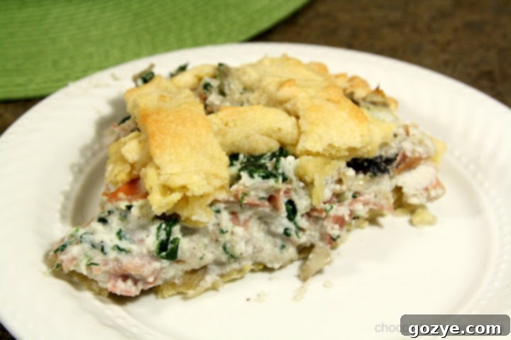 Pizza Rustica for Tuesdays With Dorie 4 A generous slice of Pizza Rustica, revealing layers of spinach, mushrooms, cheese, and prosciutto within the golden crust.