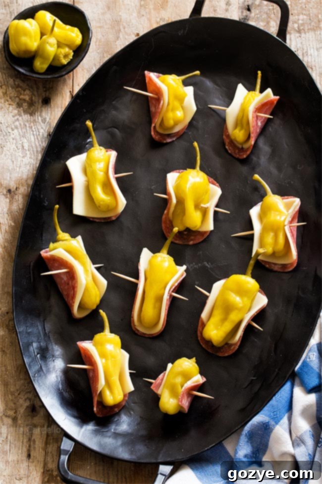 Zesty Salami Pepperoncini Rolls 3 easy three ingredient Salami Wrapped Pepperoncini on a white platter