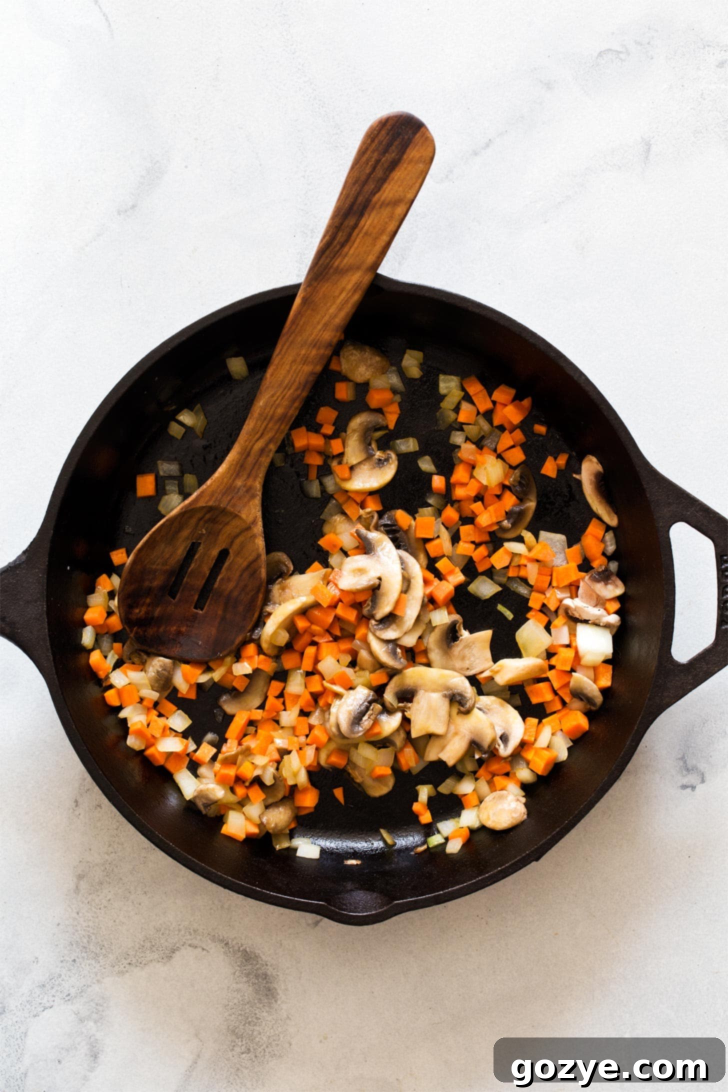 Cooking vegetables for skillet lasagna, showing onions, mushrooms, and carrots in a pan