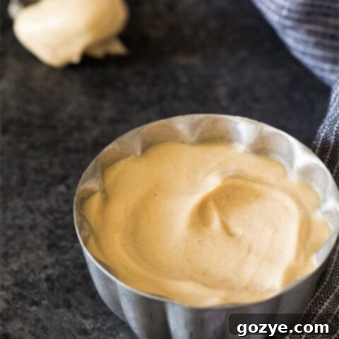 Peanut butter whipped cream in small silver bowl, garnished with peanuts