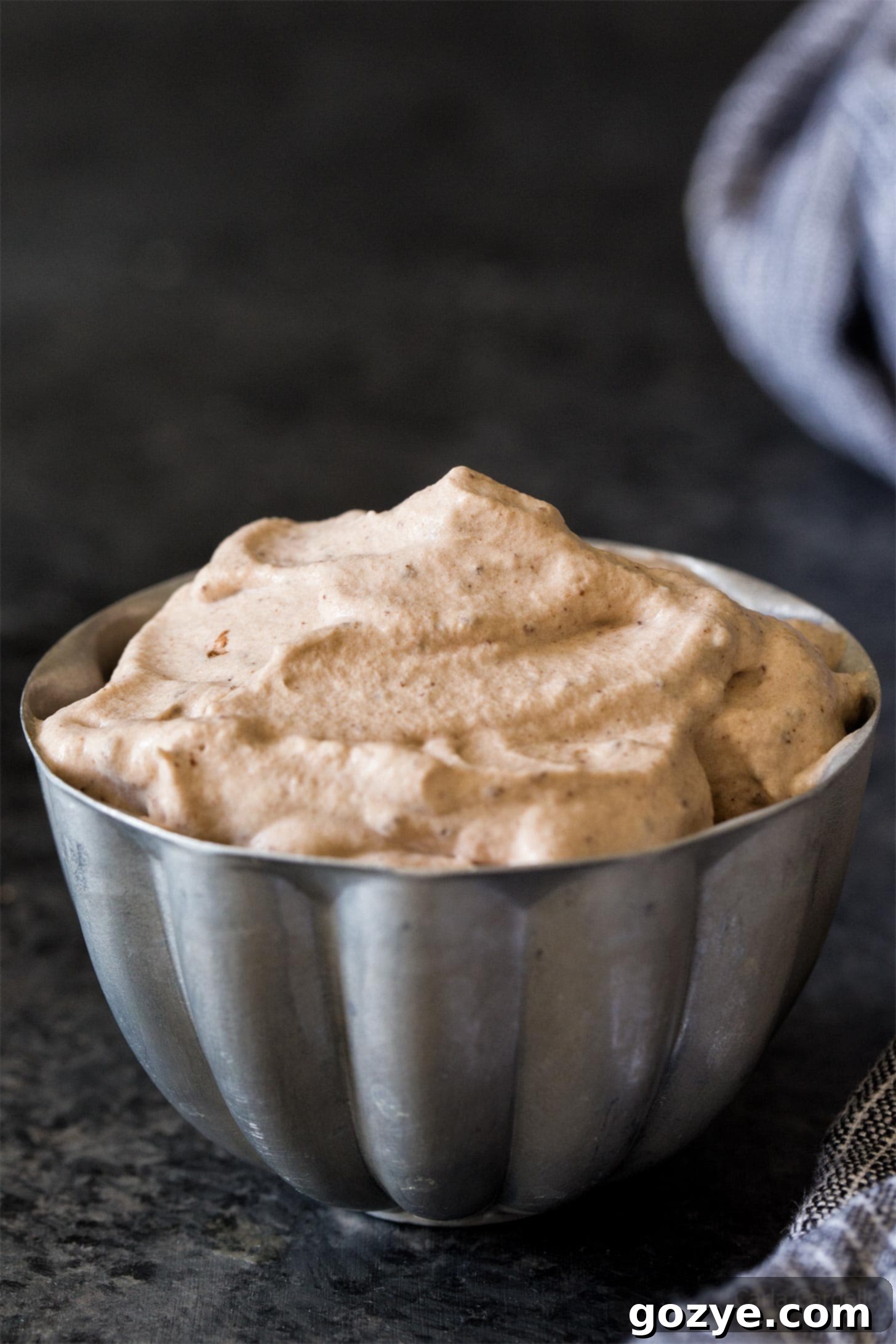 Fluffy homemade chocolate whipped cream in a small silver bowl, ready to serve