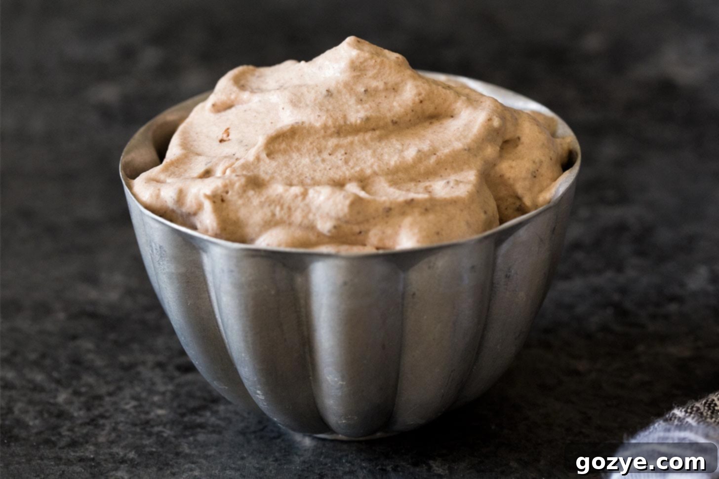 Lush cocoa whipped cream in a rustic silver bowl, ready for serving