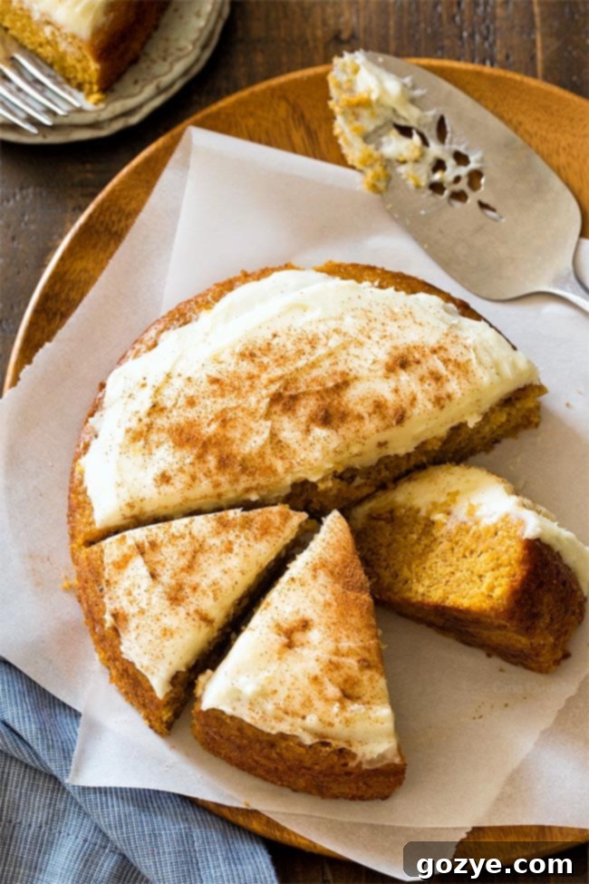 Small 6 Inch Pumpkin Cake with creamy cream cheese frosting, garnished with a sprinkle of cinnamon.