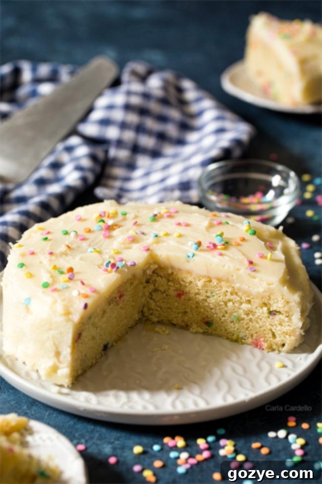 Small birthday cake with slices cut on a white plate