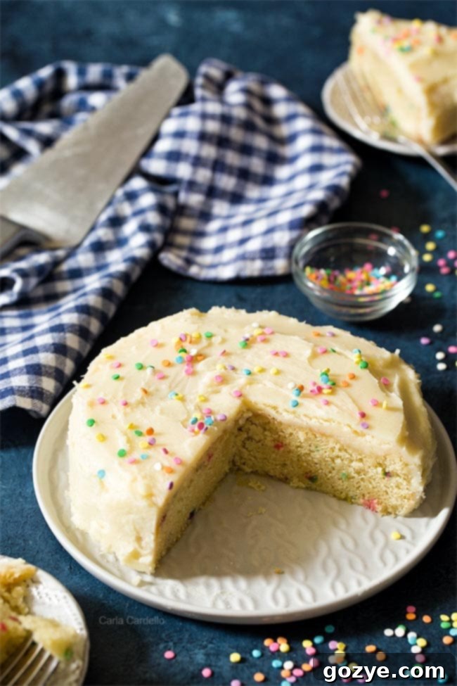 Wide shot of small birthday cake on white serving platter