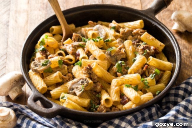 Italian Sausage Alfredo with mushrooms and rigatoni in cast iron pan