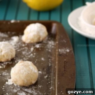 Easy Lemon Snowball Cookies dusted in powdered sugar and served in mini cupcake liners