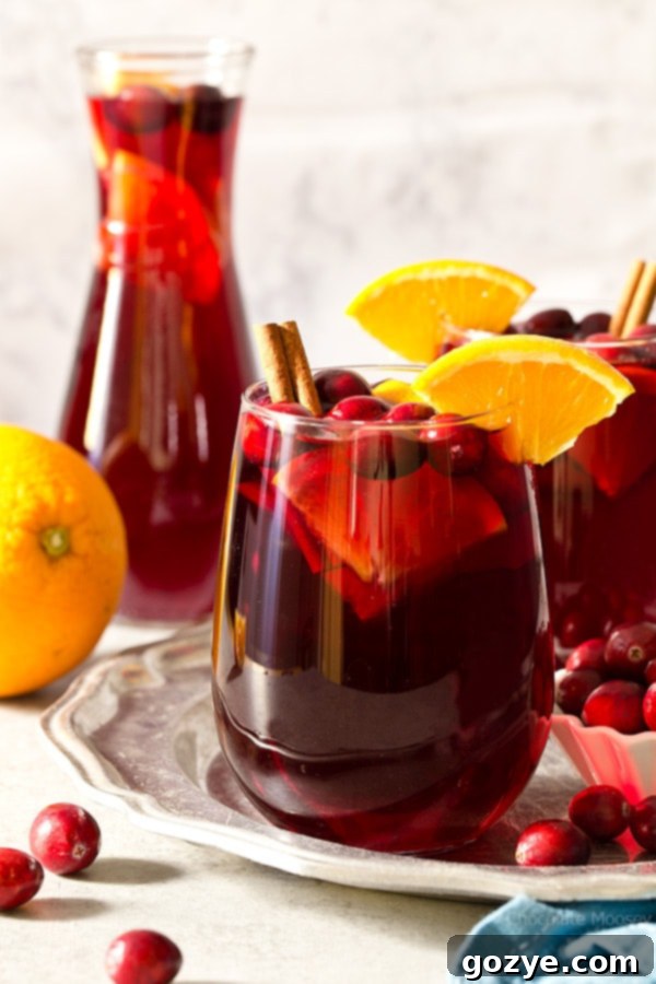 A vibrant glass of Cranberry Orange Sangria, made with red wine, cranberry juice, and fresh orange slices, perfect for a holiday cocktail.