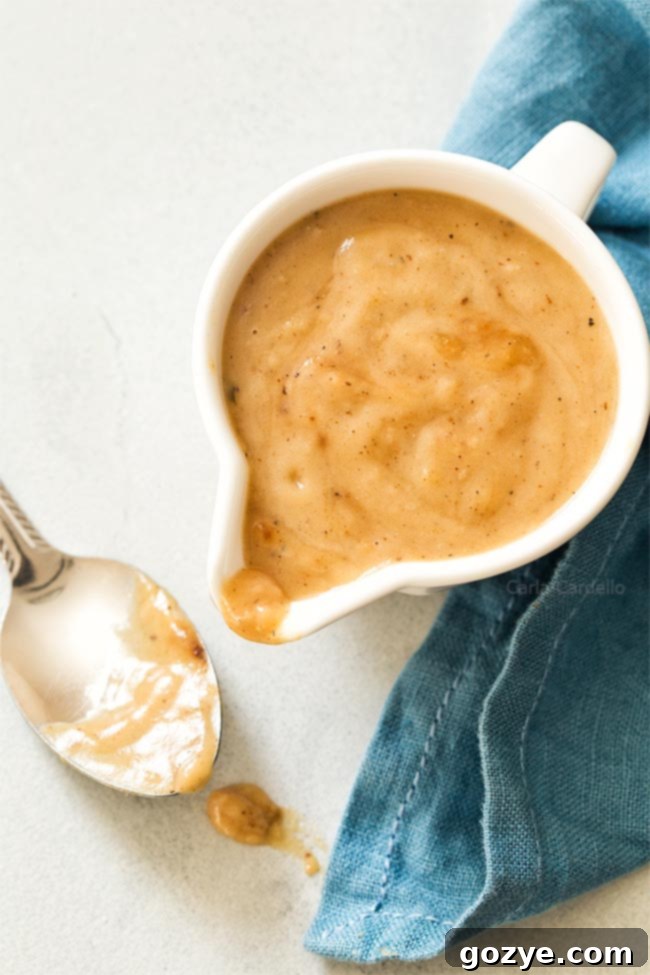 Gravy in white gravy bowl with spoon