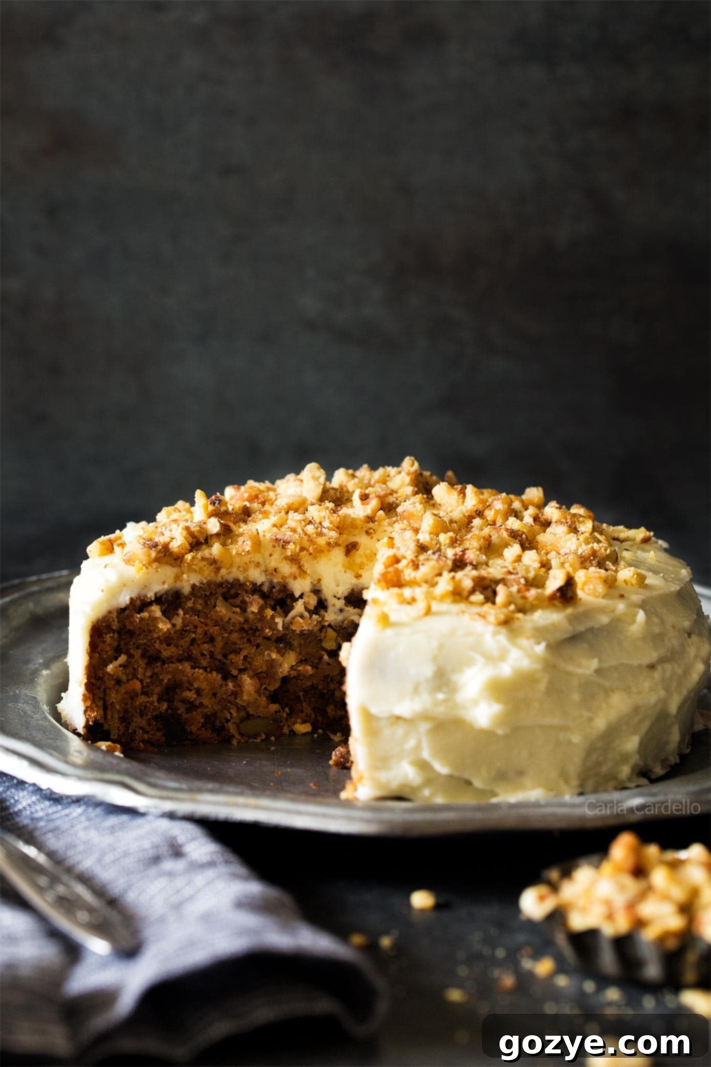 Beautifully frosted small carrot cake on a silver platter, ready to be served