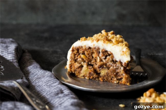 A close-up slice of Small Carrot Cake Recipe, highlighting the texture and inclusions