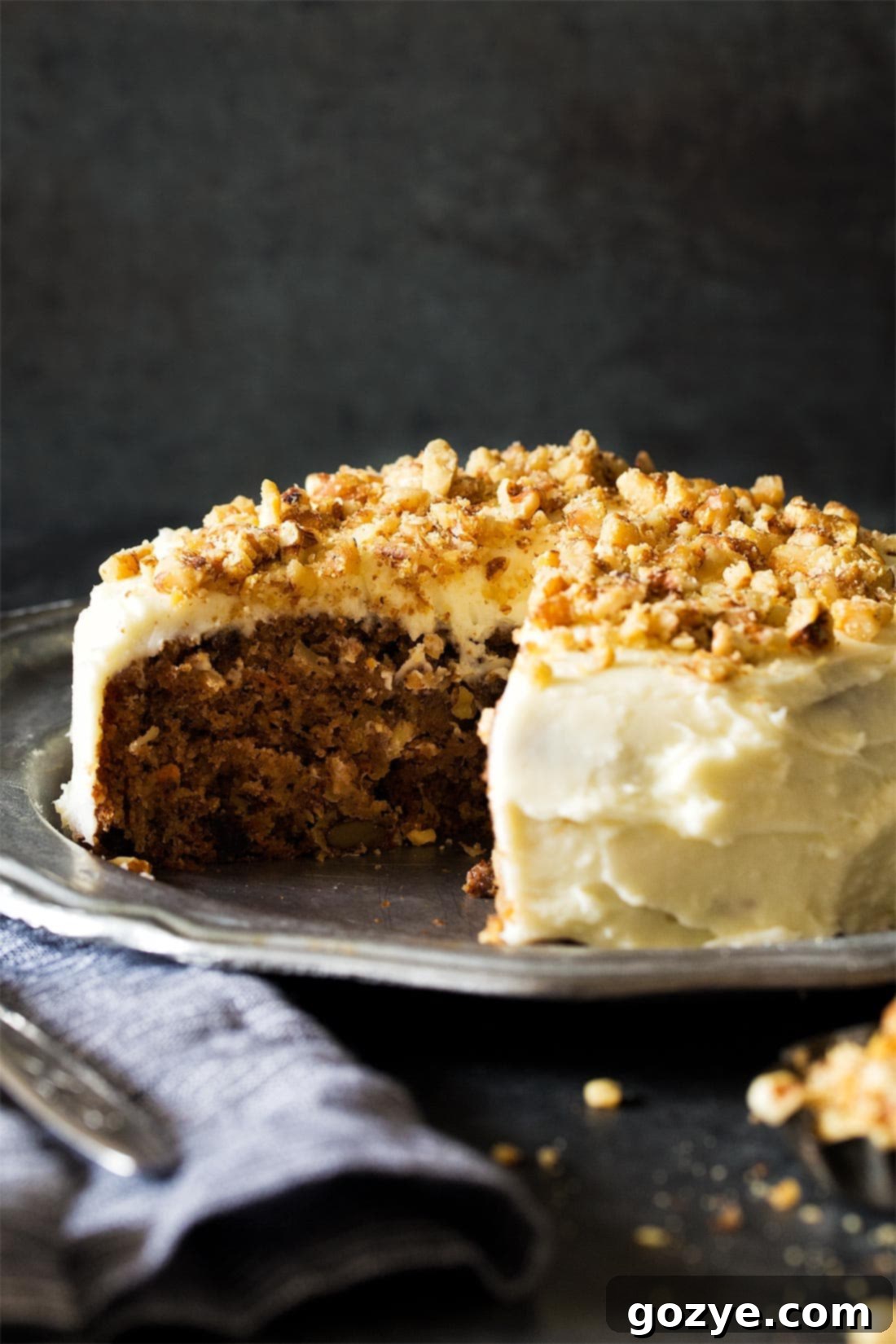 A beautifully decorated carrot cake on a silver plate, showcasing its festive appeal