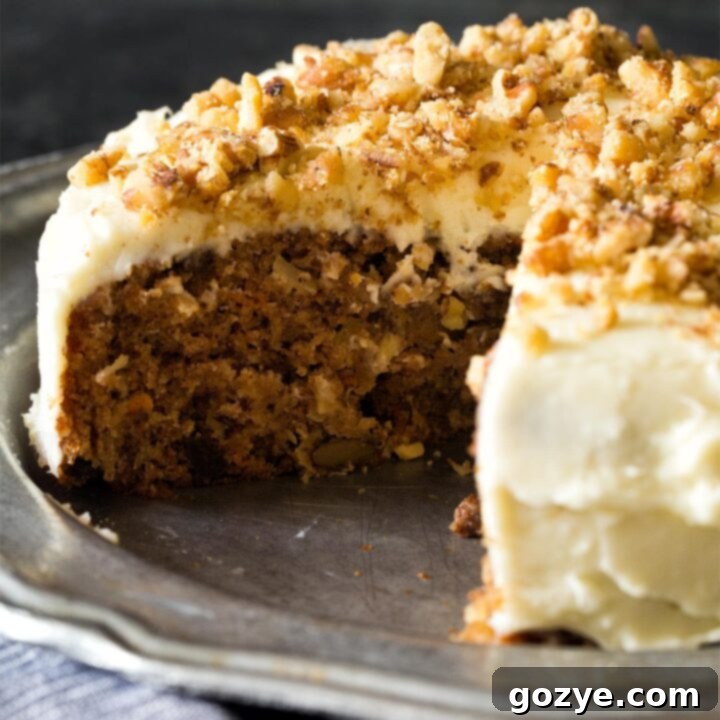 Frosted small carrot cake on a silver plate, ready to be enjoyed