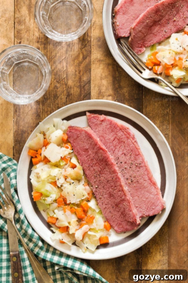 Plated Corned Beef and Cabbage with a brown rimmed dish, showcasing tender meat, vibrant cabbage, and root vegetables.