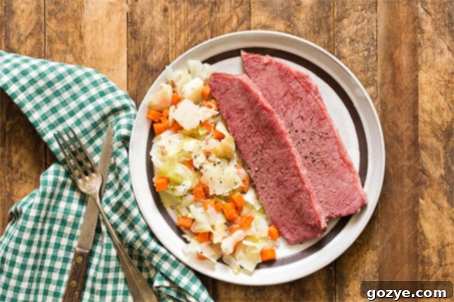 Sliced Corned Beef and Cabbage on a brown plate, served with a green napkin, illustrating the tender texture.