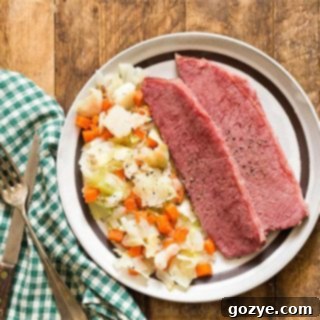 Corned Beef and Cabbage on a brown plate with a green napkin, close up of the recipe photo.