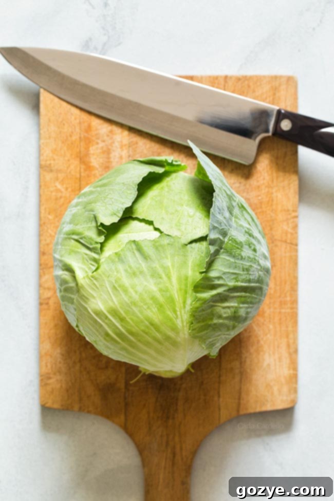 Whole cabbage on cutting board with knife