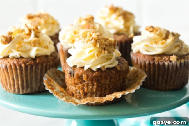 Unwrapped carrot cake cupcake on turquoise cake stand