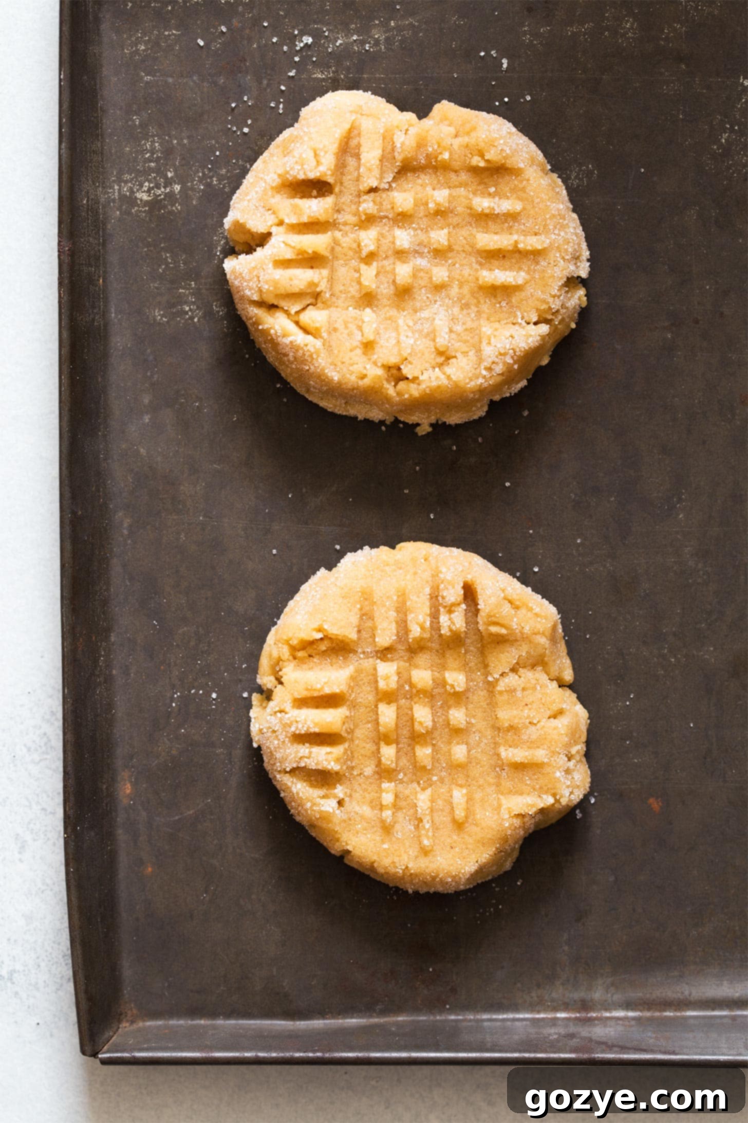 Pressing fork down to make peanut butter cookies